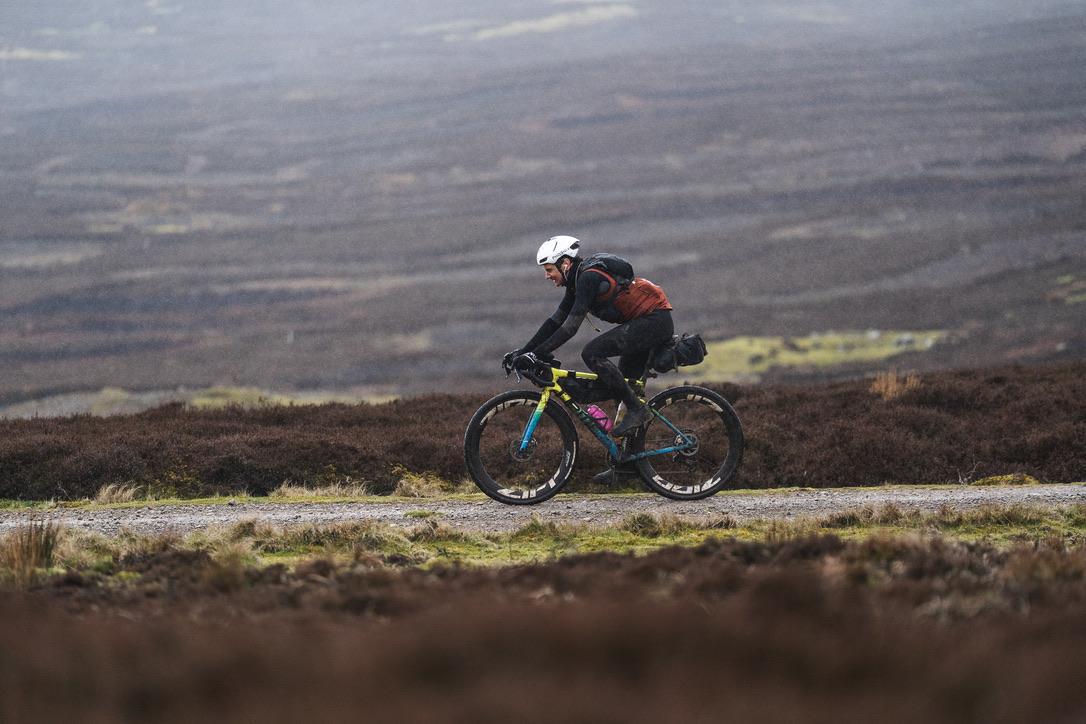 Cyclist riding on a gravel road in the hills