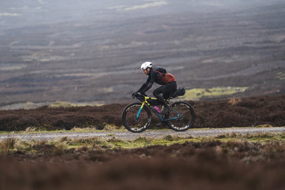 Cyclist riding on a gravel road in the hills